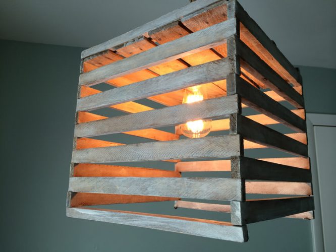 Farmhouse style light fixture made from an antique egg crate. It's easy to make using a pendant light kit and a simple white technique.