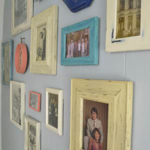 By using picture frames purchased at garage sales and thrift stores, it's easy and cheap to create a custom gallery wall!