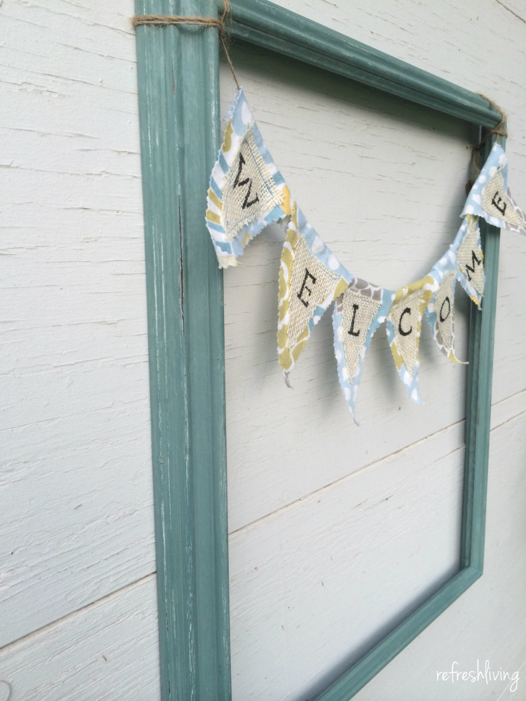 reuse an old picture frame and hang a fabric welcome banner