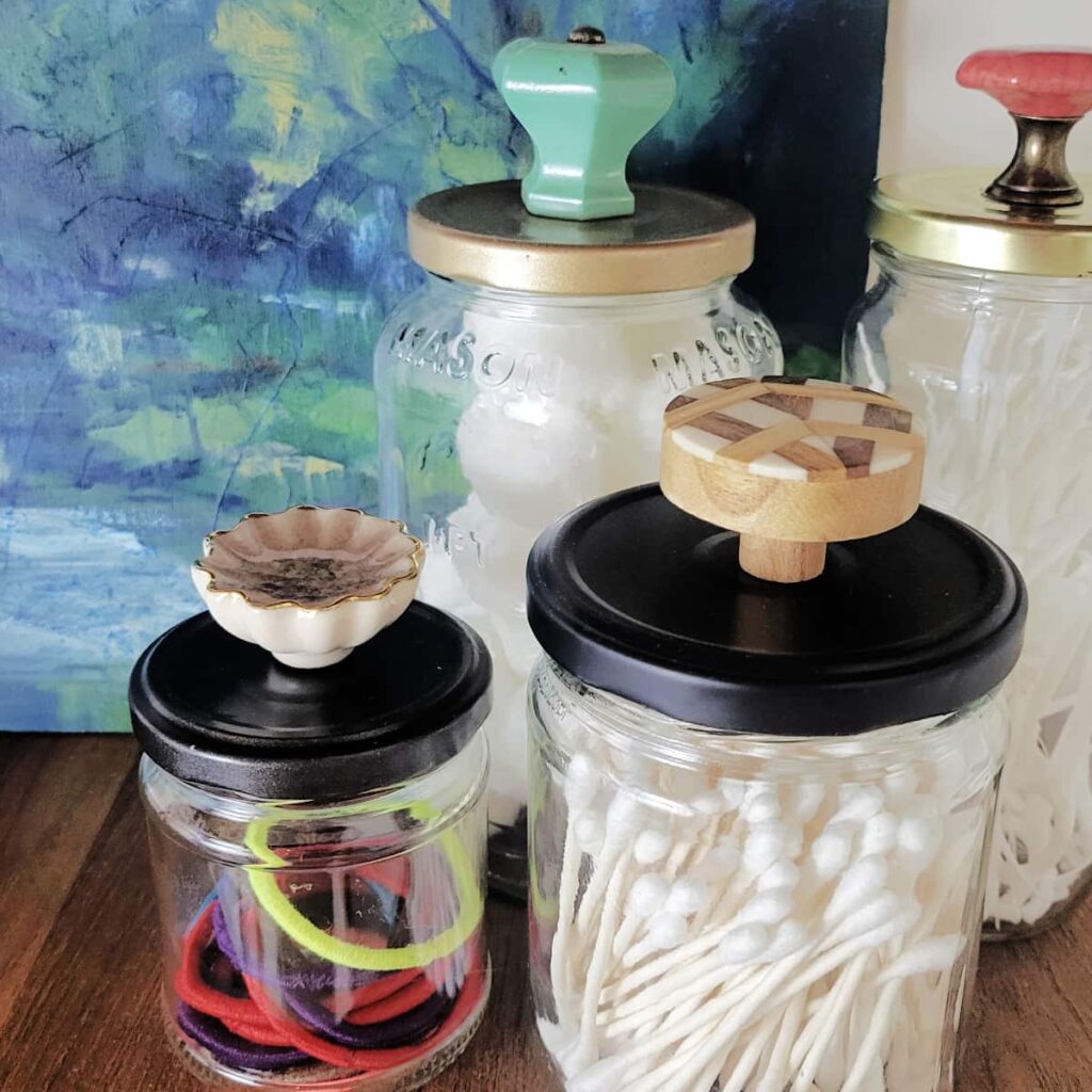 reuse glass jars as storage by attaching knobs to the top of the lids