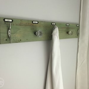 This rustic industrial towel rack is easy to make with the trick on how to attach antique glass door knobs.