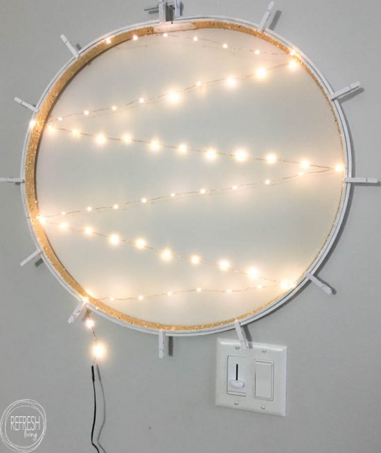 What a smart idea! Use an old embroidery hoop to create a DIY Christmas card holder, complete with copper wire fairy lights.
