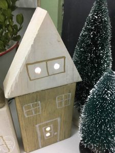 Just drill some holes in scrap wood, stick lights inside each hole, and you have a Christmas village!