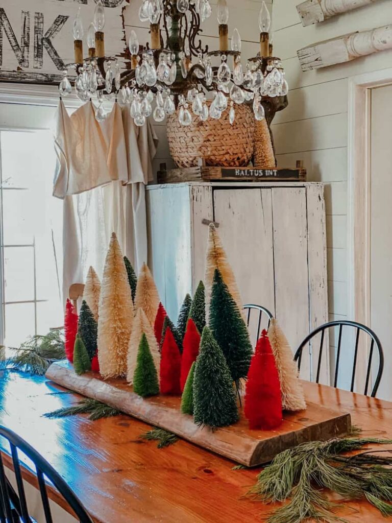 bottle brush tree centerpiece with trees stuck in large piece of wood