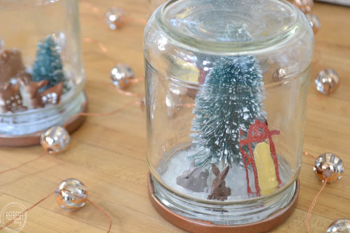 upcycled Christmas decor using glass food jars as snow globes