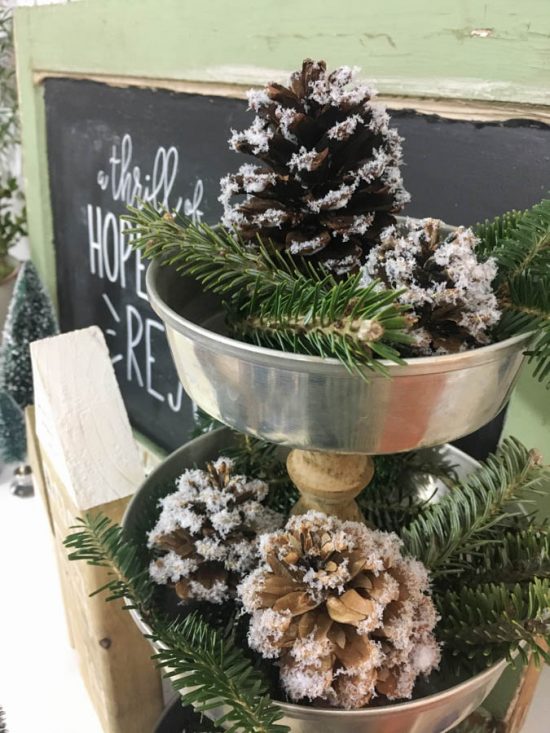 This is my kind of holiday decoration - inexpensive and easy to make! By adding fake snow to pine cones, it's easy to create natural and rustic Christmas decorations.