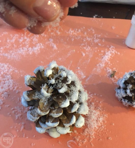 This is my kind of holiday decoration - inexpensive and easy to make! By adding fake snow to pine cones, it's easy to create natural and rustic Christmas decorations.