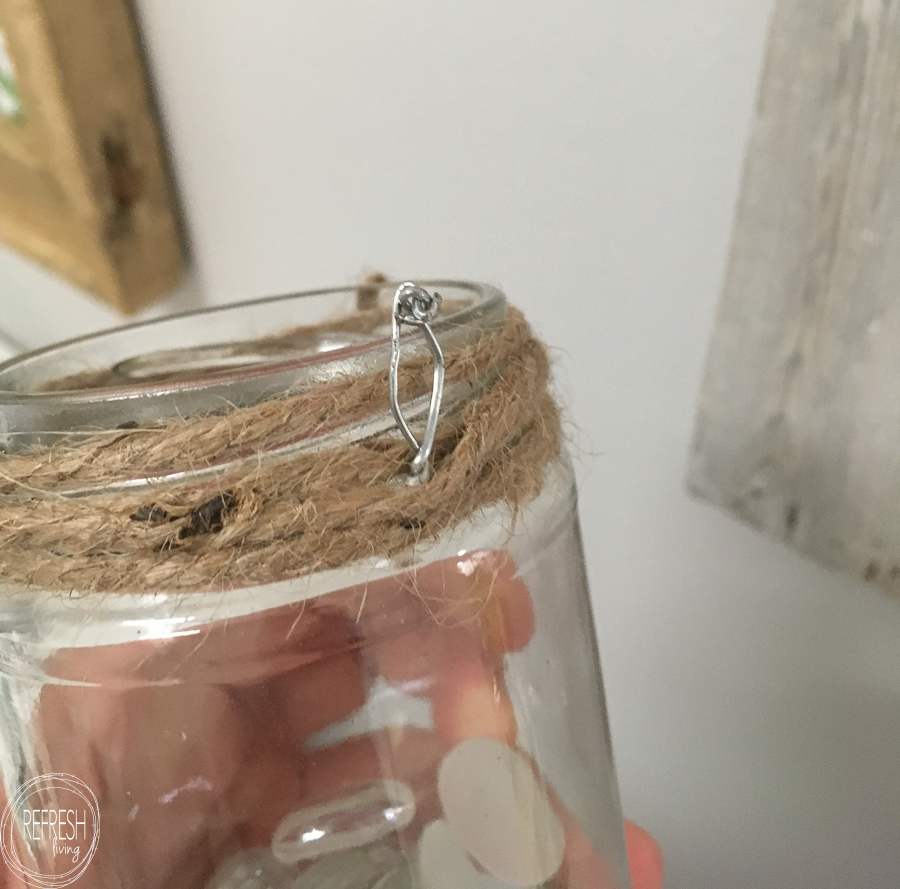 add wire and twine to turn a glass jar into a hanging flower vase to attach to a wood sign