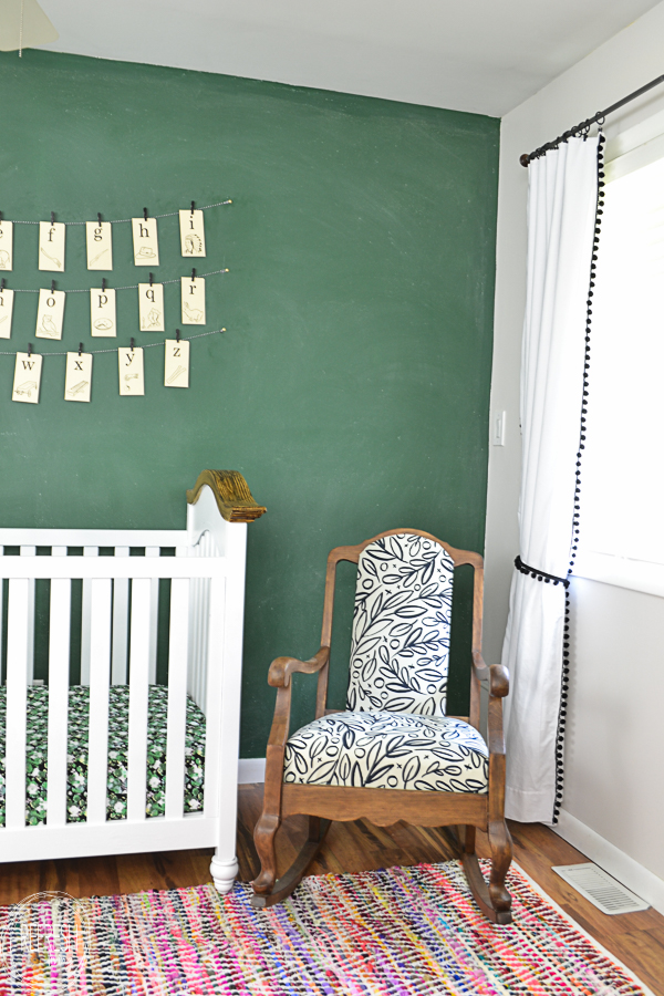 green chalkboard wall in nursery with vintage rocking chair wood with black and white fabric