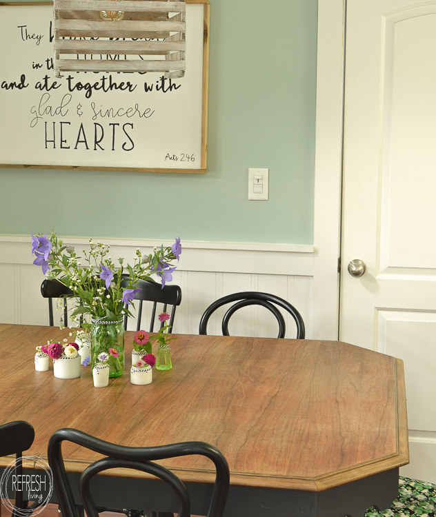 This dining room table only cost $37 at a thrift store! After stripping and bleaching the top and painting the base, it looks like a new piece of furniture! Refinished farmhouse table with natural wood top and painted gray base.