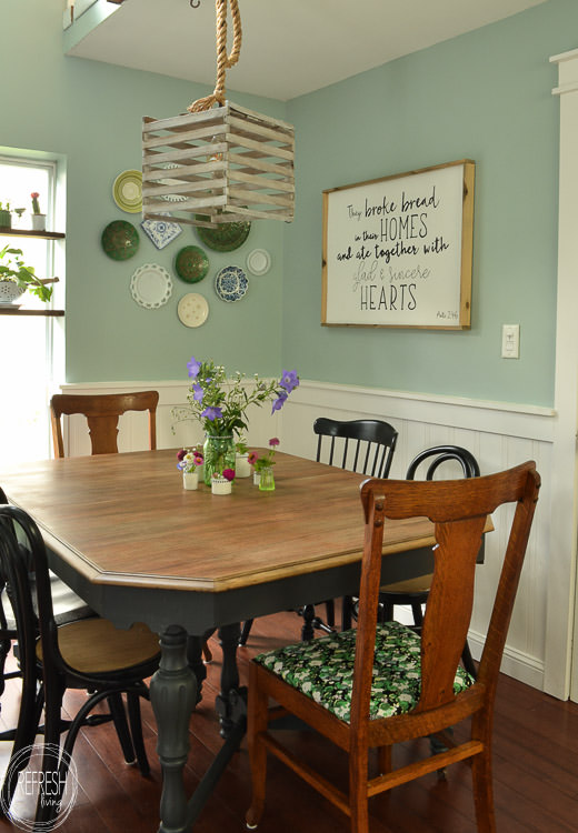 This dining room table only cost $37 at a thrift store! After stripping and bleaching the top and painting the base, it looks like a new piece of furniture! Refinished farmhouse table with natural wood top and painted gray base.