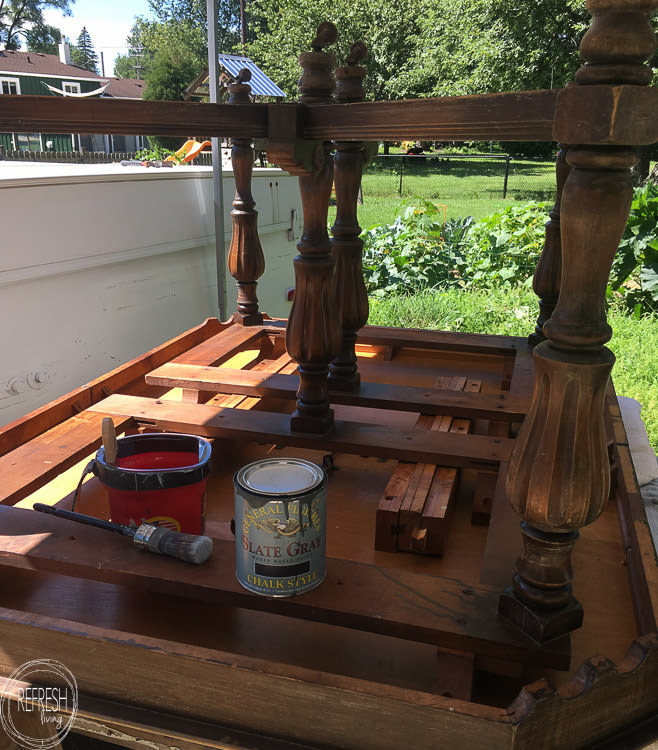 This dining room table only cost $37 at a thrift store! After stripping and bleaching the top and painting the base, it looks like a new piece of furniture! Refinished farmhouse table with natural wood top and painted gray base.