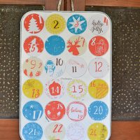 This DIY advent calendar is upcycled from an old muffin pan. Magnetic cut outs cover the holes and are easy to remove. Plus, there is a free printable for the numbered circles!