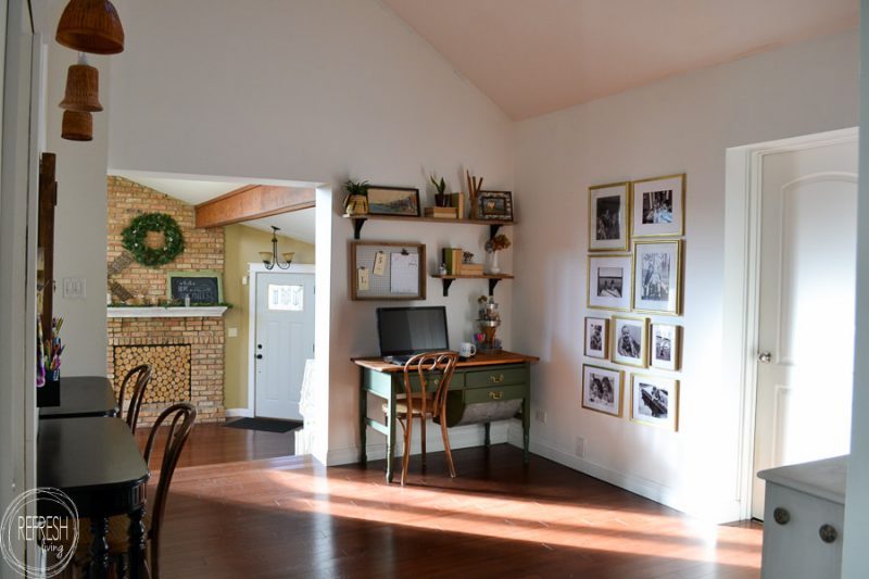 This office has a vintage farmhouse feel with modern touches including a dark green desk, brass and gold accents, and open shelves.