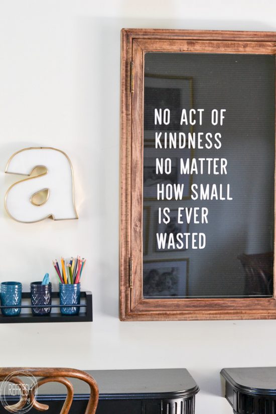 This office has a vintage farmhouse feel with modern touches including a dark green desk, brass and gold accents, and open shelves.