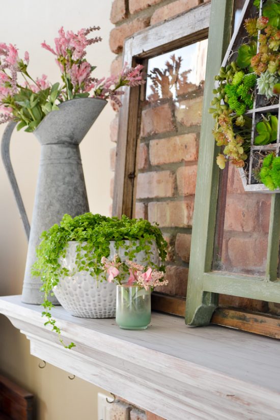 This spring decor has a vintage farmhouse feel. Mantel decorated for spring with green and pink, old windows, and succulents. Spring home tour with upcycled and vintage finds.