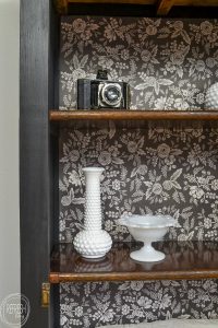 I love how this piece was refinished with black paint contrasting with the wood and the modern black and white floral background.