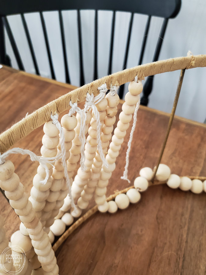 I saved hundreds of dollars by making this farmhouse light fixture! This DIY beaded chandelier was made from a $10 thrift light fixture, an old lampshade, and lots of beads.
