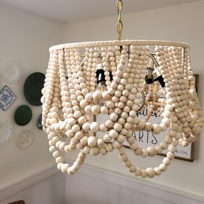 I saved hundreds of dollars by making this farmhouse light fixture! This DIY beaded chandelier was made from a $10 thrift light fixture, an old lampshade, and lots of beads.