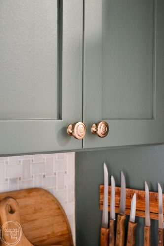 These champagne bronze knobs look perfect with green cabinets. It looks like a subtle brushed brass finish that is modern and goes well with any color.