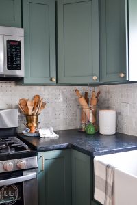 This budget friendly kitchen makeover is perfect with green cabinets, soapstone counters, and a marble backsplash. A perfect mix of modern and vintage touches creates a beautiful space.