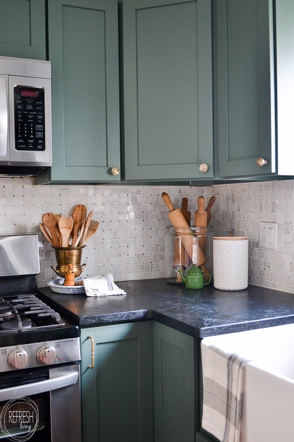 kitchen with green cabinets, soapstone counters, and marble backsplash ...