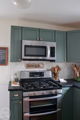 kitchen with green cabinets, soapstone counters, and marble backsplash ...