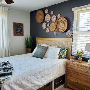 bedroom with black shiplap wall and cane headboard