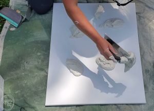 Such an easy way to make large scale art for cheap using canvas artwork and drywall mud. Video tutorial and step by step process for how to make a DIY modern art on canvas