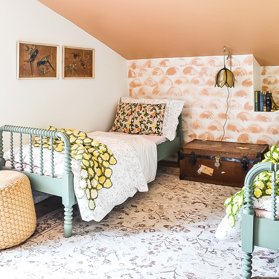 girls bedroom with peach ceiling and peach walls with painted wallpaper design and green bed