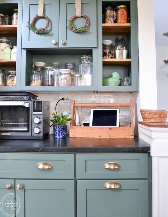 Natural wreaths on green kitchen cabinets are an easy DIY project with items from the craft store.