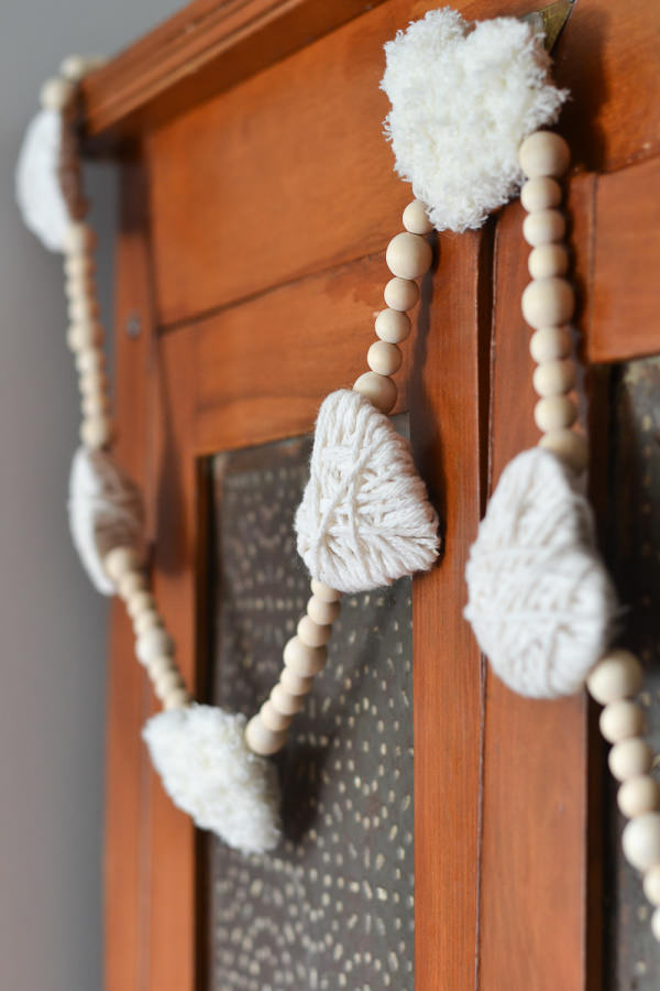 valentines garland with wood beads and white yarn wrapped hearts