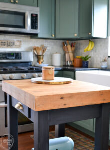 small kitchen island with butcher block top and black base