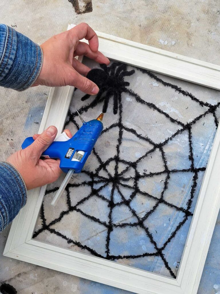 make spider webs by gluing yarn into old picture frames