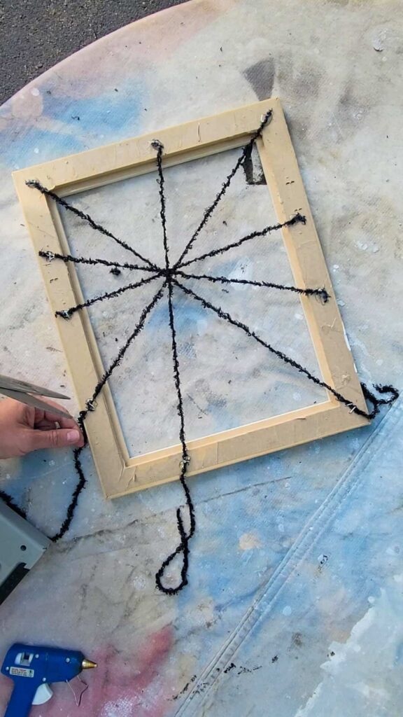 make spider webs by gluing yarn into old picture frames