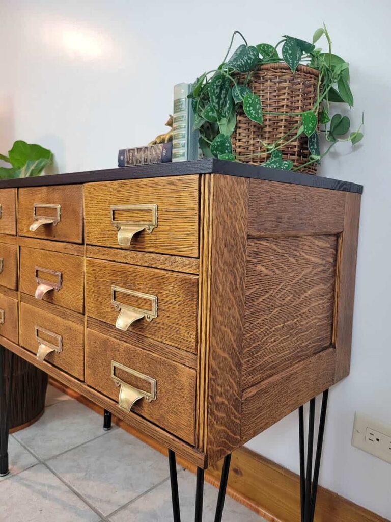 refinished antique card catalog with natural quatersawn oak finish, hairpin legs, black top and brass pulls