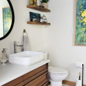 mid century modern bathroom ideas with MCM vanity, decorative wood ceiling, a black ceiling, floating shelves, marble vanity top, colorful artwork